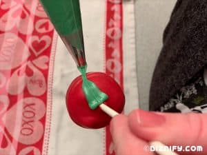 adding green white chocolate leaves to cake pop